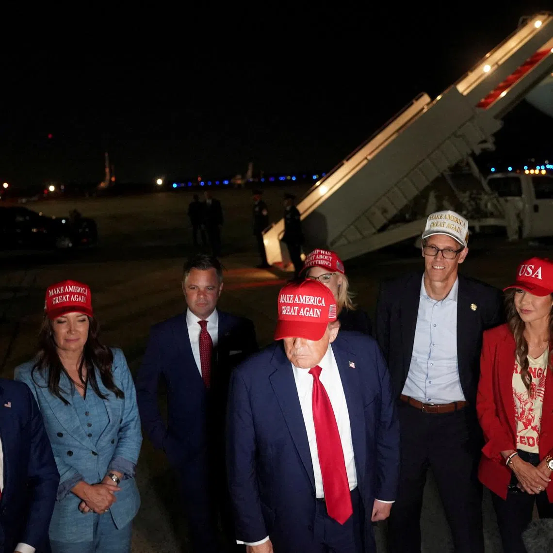 FILE PHOTO: U.S. President Donald Trump stands with U.S. Homeland Security Secretary Kristi Noem, Agriculture Secretary Brooke Rollins, Interior Secretary Doug Burgum, Representative Randy Feenstra (R-IA),  Representative Zach Nunn (R-IA), Rep. Mariannette Miller-Meeks (R-IA) and Representative Ashley Hinson (R-IA), upon arrival at Joint Base Andrews following a visit to Iowa, at Joint Base Andrews, Maryland, U.S. July 4, 2025. REUTERS/Nathan Howard/File Photo