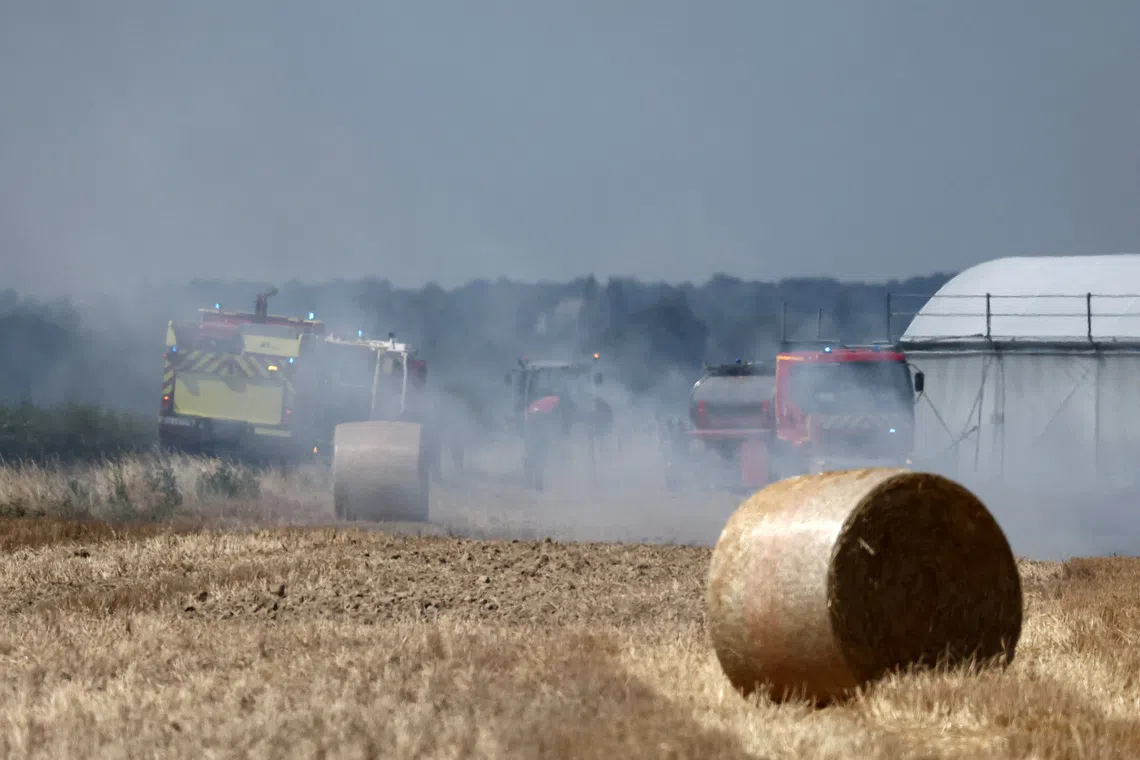 FILE PHOTO: French firefighters work to extinguish burning haystacks in a field at a farm near Loretz-d'Argenton, in the Deux-Sevres department, during a heatwave affecting a majority of the country, France, June 25, 2026.  REUTERS/Stephane Mahe/File Photo