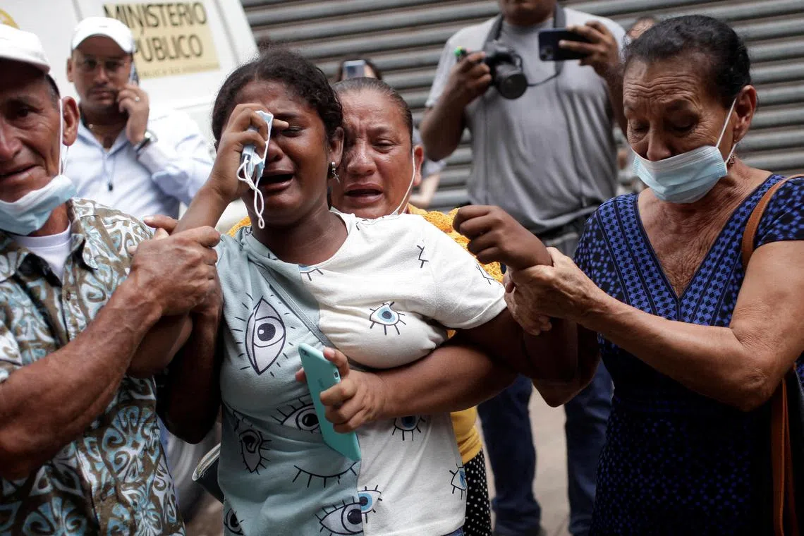 Relatives wait to collect their loved ones outside the morgue. Some victims of the violence were shot and others died in a fire that broke out at the prison.
