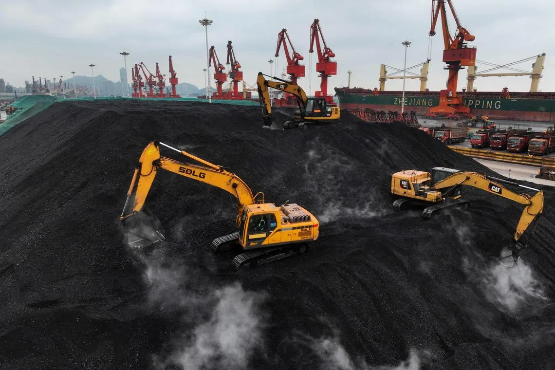 Diggers pile coal after it was unloaded from a ship at the coal terminal of Lianyungang Port, in China’s eastern Jiangsu province on December 15, 2023. (Photo by AFP) / China OUT