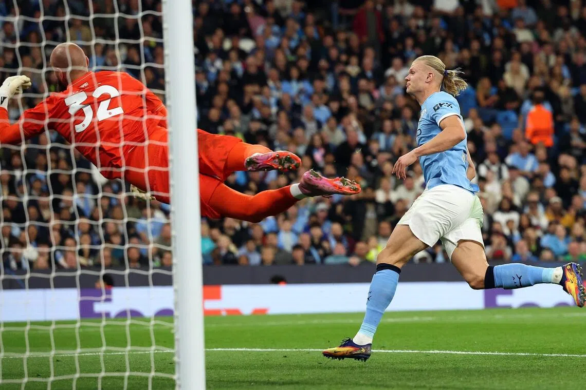 Manchester City's Erling Haaland scores his team's first goal - his 50th in the Champions League - past Napoli goalkeeper Vanja Milinkovic-Savic.