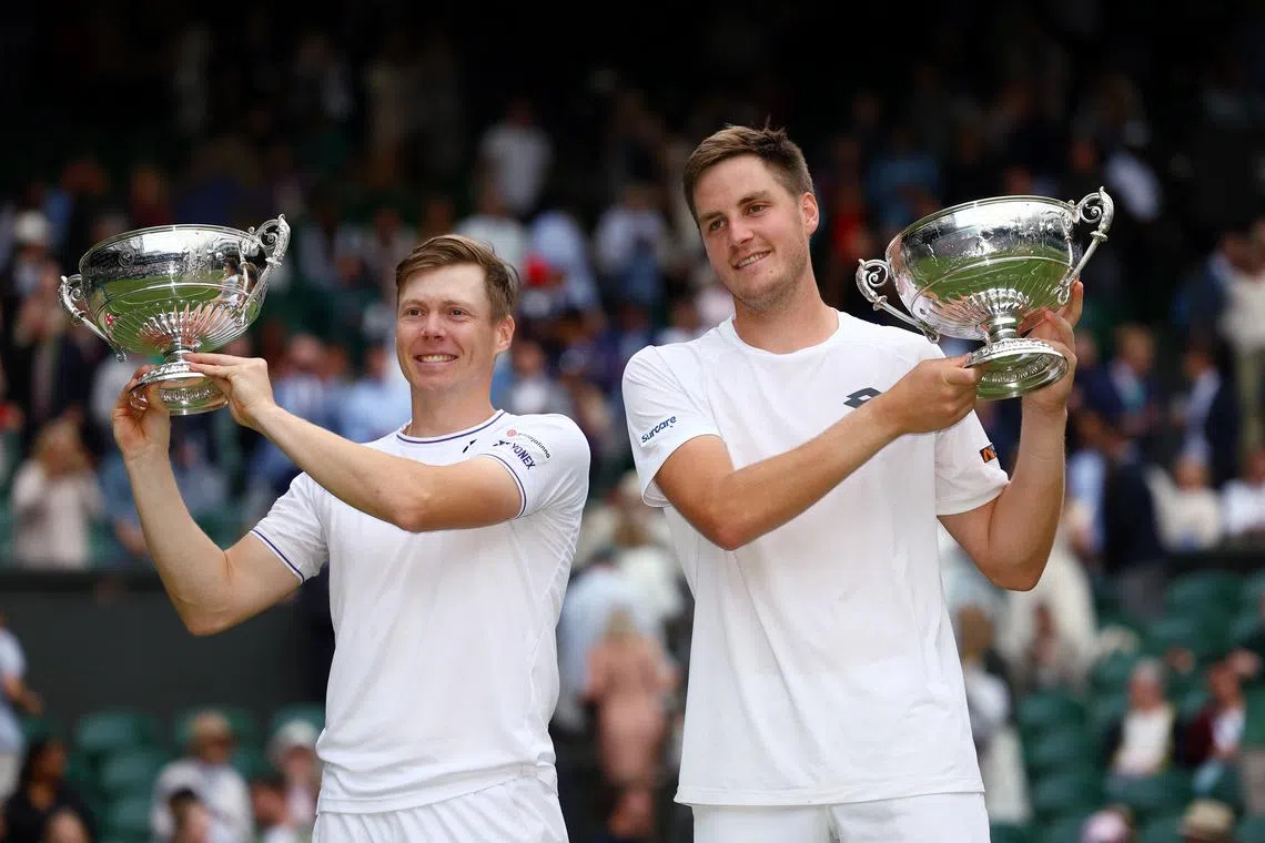 Tennis - Wimbledon - All England Lawn Tennis and Croquet Club, London, Britain - July 13, 2024 Britain's Henry Patten and Finland's Harri Heliovaara celebrate with their trophies after winning the men's doubles final against Australia's Max Purcell and Australia's Jordan Thompson REUTERS/Paul Childs