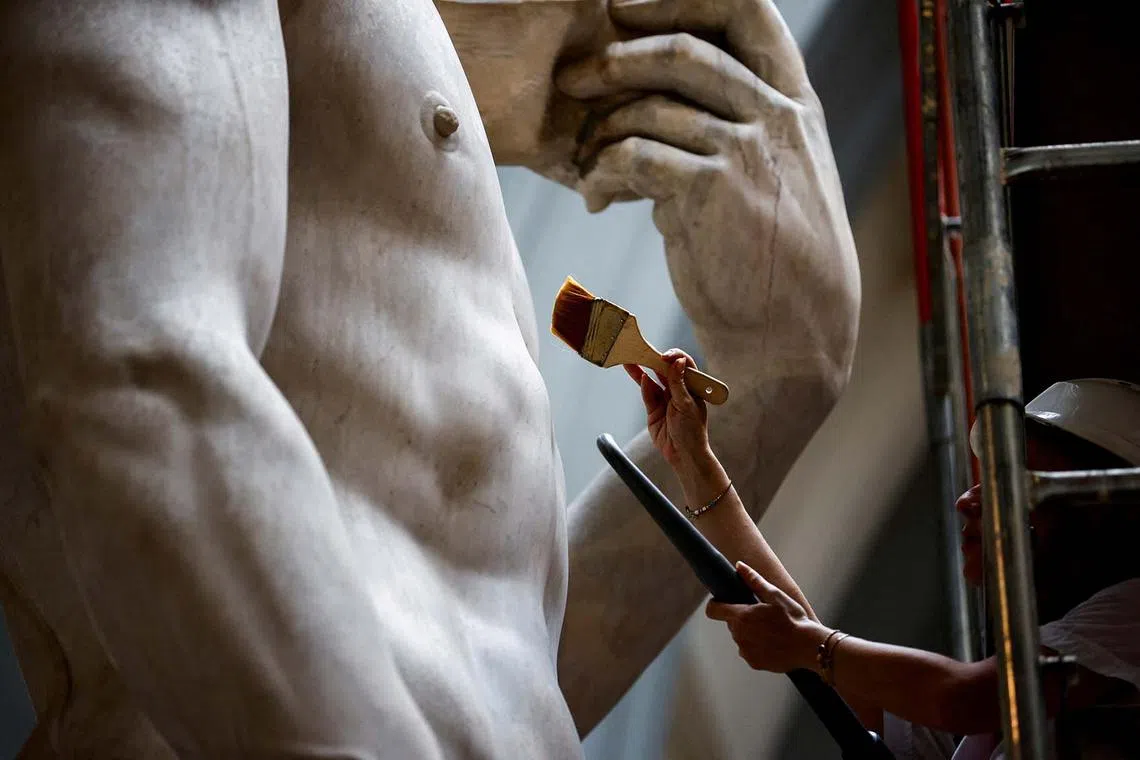 Restorer Eleonora Pucci cleans dust and debris off Michelangelo's statue of David using a backpack vacuum and synthetic fibre brush at the Galleria dell'Accademia, in Florence, Italy, Sept 25.