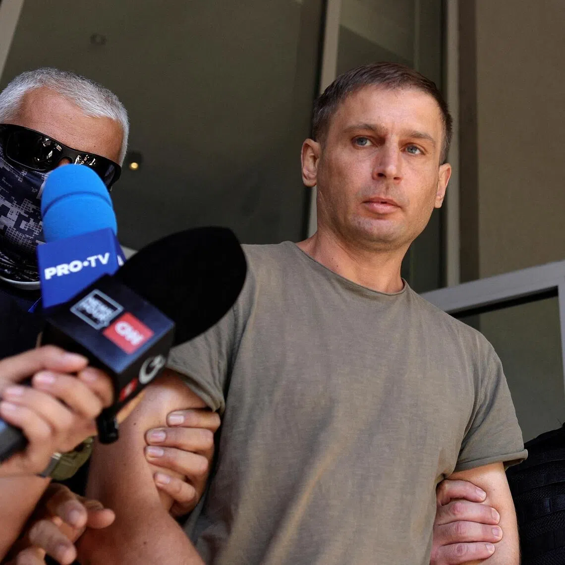 A Russian citizen believed to be involved in a thwarted sabotage operation coordinated by Russia on Romanian territory is escorted by officers in Bucharest, on Sept 8.