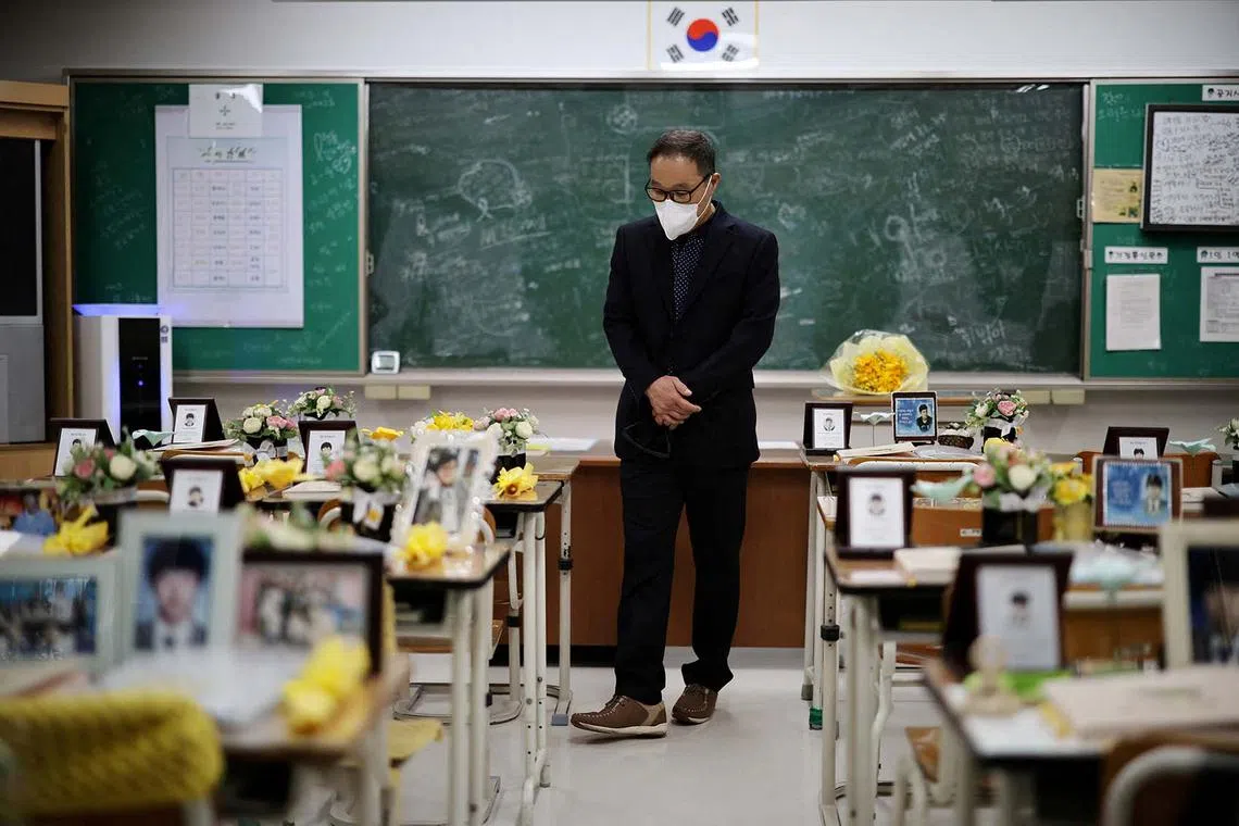 A man taking a look around a replicated classroom of students who died in the sunken Sewol ferry disaster that killed 304 people, mostly school students, in Ansan, South Korea, April 16, 2024. 