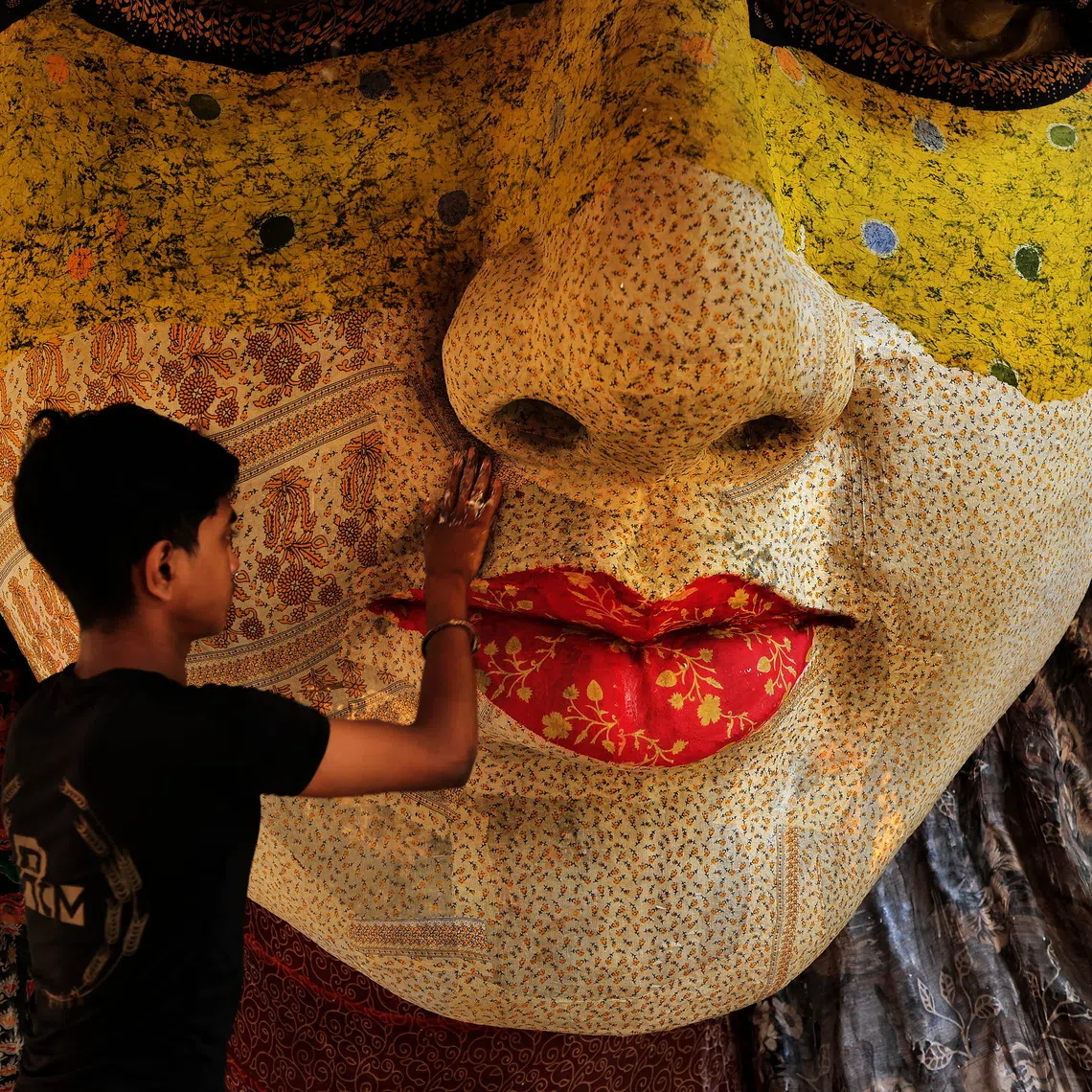 epaselect epa13272672 An Indian artisan works on a paper-mache face mask inside a temporary festival marquee (pandal) under construction ahead of the Durga Puja festival in Kolkata, India, 30 September 2026. The major Hindu festival, which celebrates the victory of Goddess Durga over the demon Mahishasura to symbolize the triumph of good over evil, will run from 16 through 21 October. EPA/PIYAL ADHIKARY