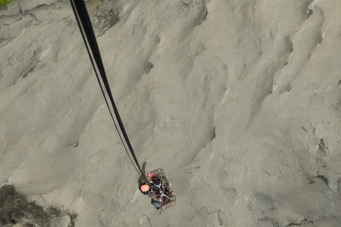 FILE PHOTO: A member of the Nepalese army airlifts people stranded during the flood at Bhotekoshi river, Nepal, July 8, 2025. Nepal Army/Handout via REUTERS/File Photo