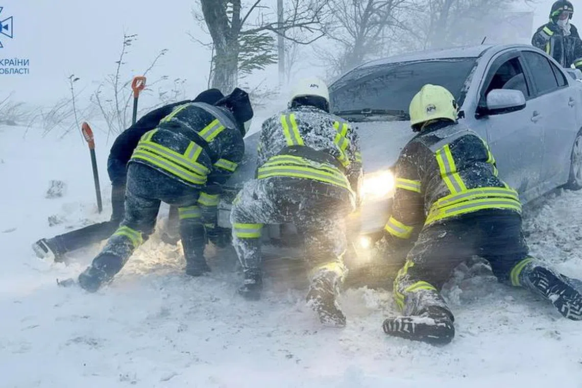 Emergency workers release a car which stuck in snow during a heavy snow storm in Odesa region, Ukraine in this handout picture released November 27, 2023. Press service of the State Emergency Service of Ukraine in Odesa region/Handout via REUTERS