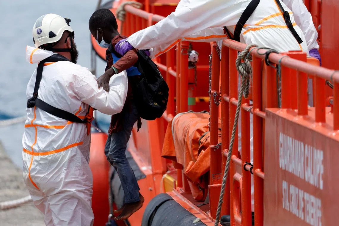 FILE PHOTO: A rescuer helps a migrant child disembark from a Spanish coast guard vessel in the port of Arguineguin, in the island of Gran Canaria. Spain, June 3, 2023. REUTERS/Borja Suarez/File Photo