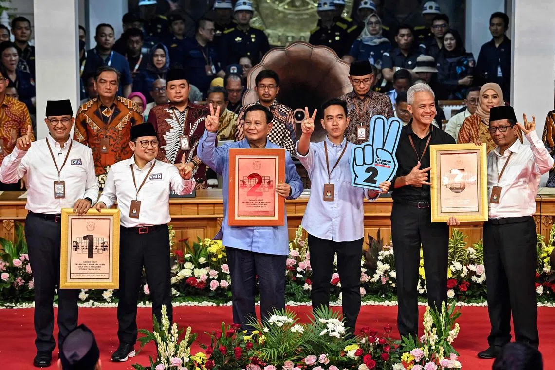 Presidential candidates Anies Baswedan (L), Prabowo Subianto (3L) and Ganjar Pranowo (2R) along with vice presidential candidates Muhaimin Iskandar (2L), Gibran Rakabuming Raka (3R) and Mahfud MD (R) pose after the drawing of ballot numbers for the presidential and vice presidential candidates at the General Elections Commission (KPU) office in Jakarta on November 14, 2023. Indonesia's election commission on November 13, announced the candidates for next year's presidential vote when the world's third largest democracy is due to pick a successor to incumbent leader Joko Widodo. (Photo by Adek BERRY / AFP)