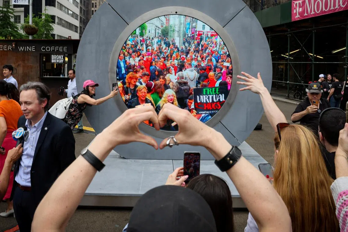 New Yorkers greet people in Dublin during the reveal of The Portal, a public technology sculpture that links between Dublin and New York.   