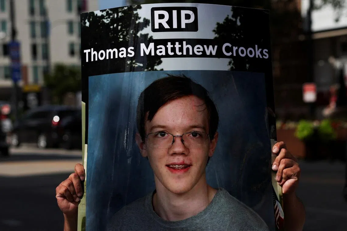 A man holds a sign with a picture of Thomas Crooks, following a shooting during a rally in which Republican presidential nominee and former U.S. President Donald Trump was injured, outside the Republican National Convention (RNC), in Milwaukee, Wisconsin, U.S., July 17, 2024. REUTERS/Shannon Stapleton