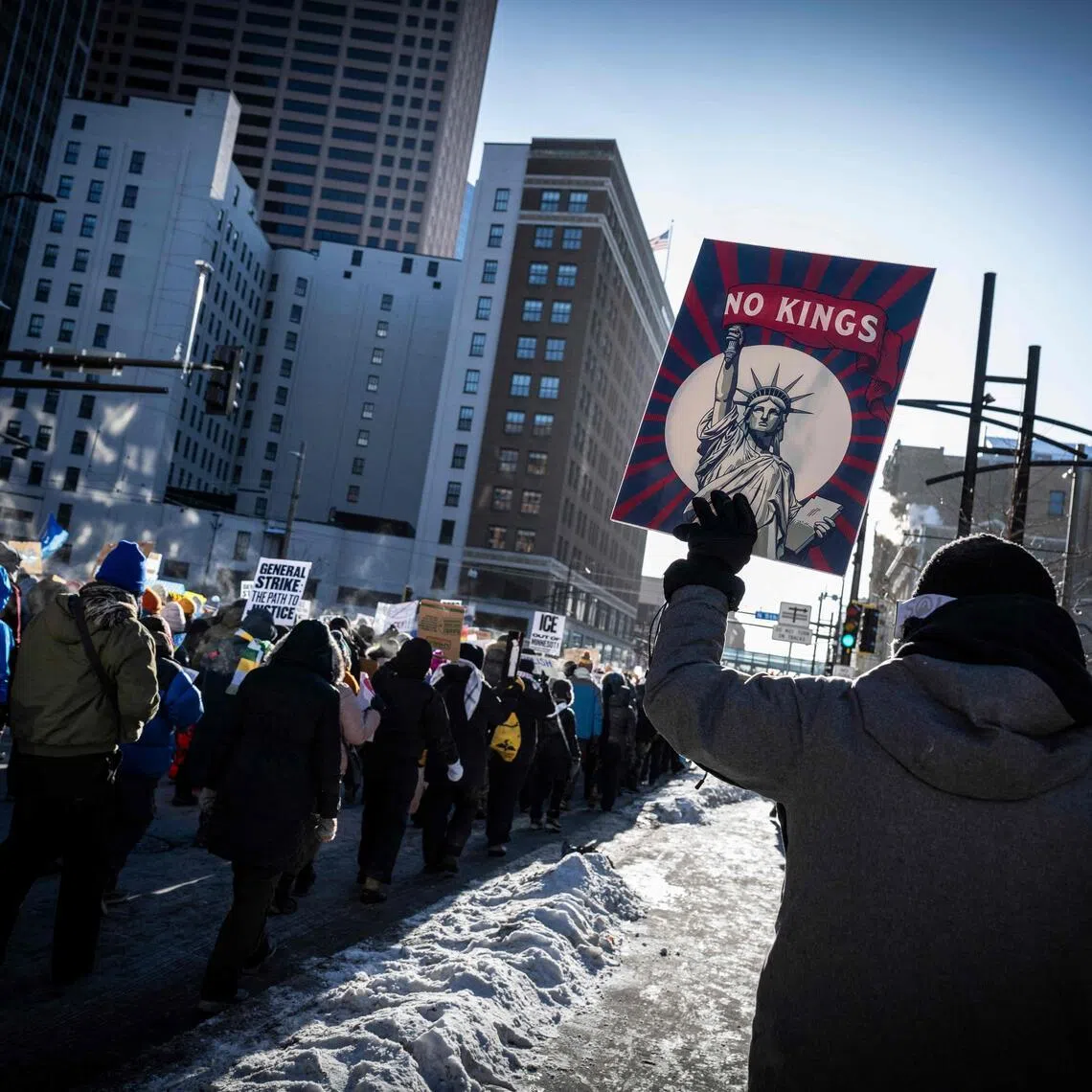 A person holds a "No Kings" sign as people march during the "ICE out of Minnesota: Day of Truth and Freedom" protest in Minneapolis, Minnesota on Jan 23, 2026. 