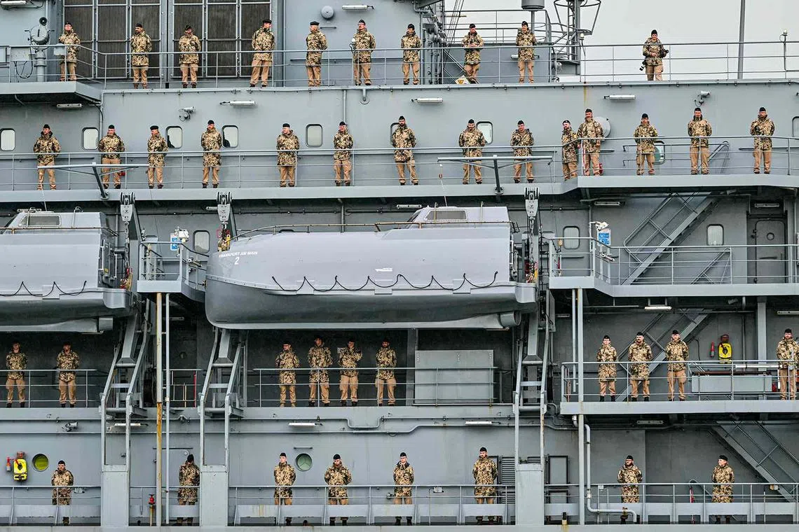 TOPSHOT - Crew members of the German navy replenishment ship Frankfurt am Main stand on deck as they approach Port Klang on the outskirts of Kuala Lumpur on October 15, 2024. (Photo by Mohd RASFAN / AFP)