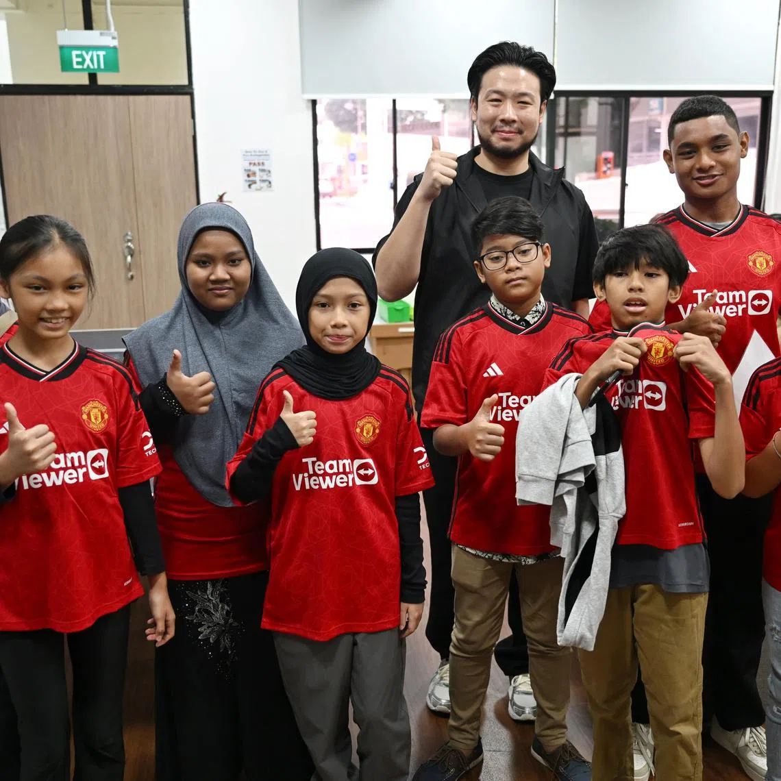 Mr Kiat Lim (in black) with the eight children and youth going to Manchester.