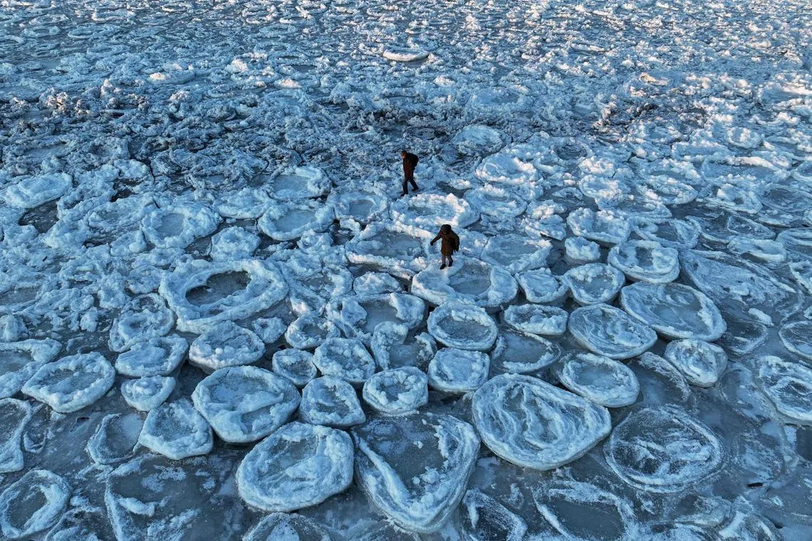 This aerial photograph taken on Feb 3, 2026 showing people walking on the frozen Baltic Sea near Mikoszewo, northern Poland. 