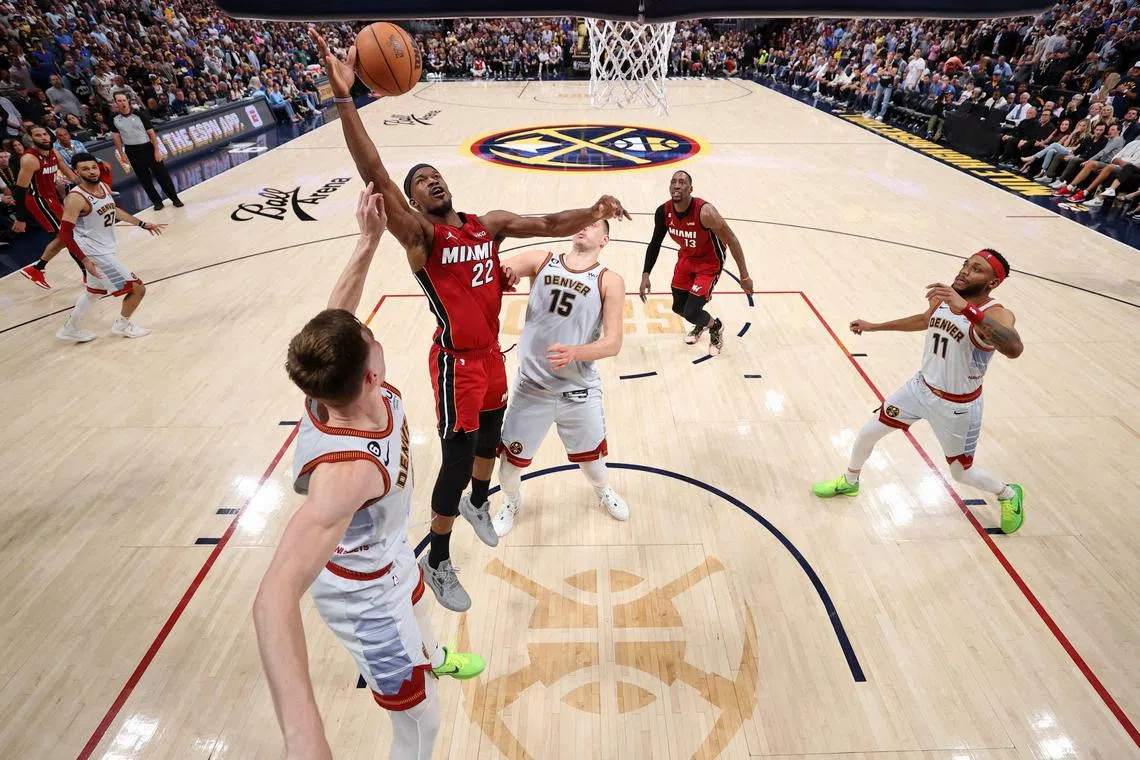 Miami Heat forward Jimmy Butler reaches for the ball against the Denver Nuggets during Game 5 of the NBA Finals.