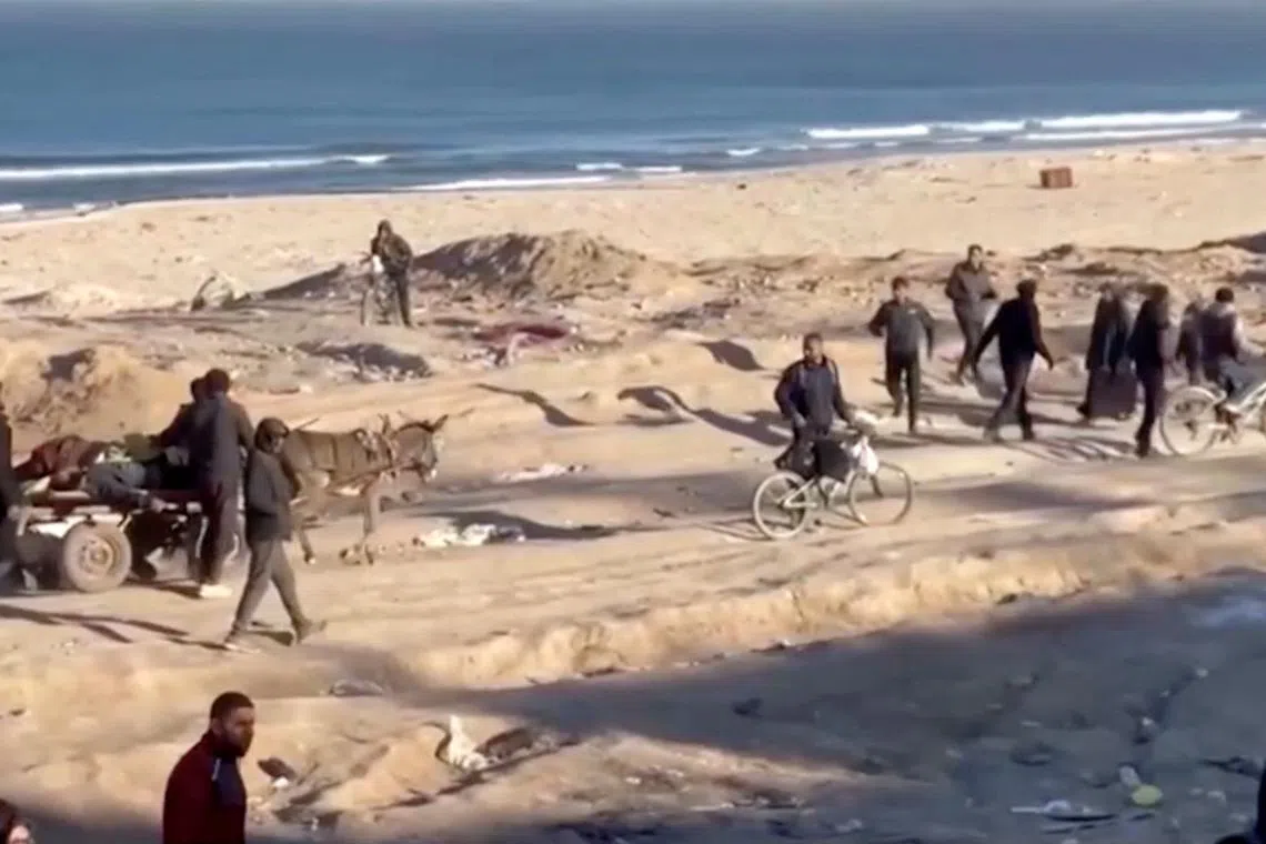 Palestinians transport casualties following what Palestinian health officials said was Israeli fire on people waiting for aid, in Gaza City, in this still picture taken from a video February 29, 2024. REUTERS TV via REUTERS