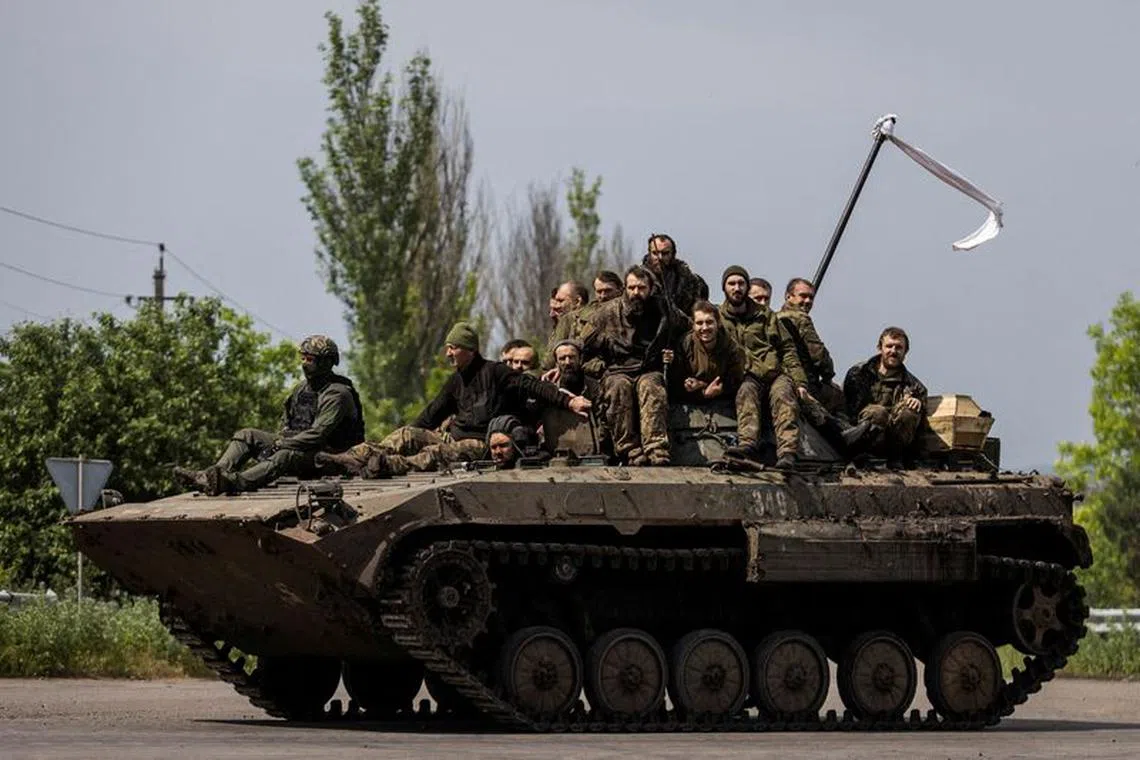 FILE PHOTO: Ukrainian prisoners of war (POWs) ride atop of an infantry fighting vehicle after a swap, amid Russia's attack on Ukraine, in Donetsk region, Ukraine May 25, 2023. REUTERS/Yevhenii Zavhorodnii