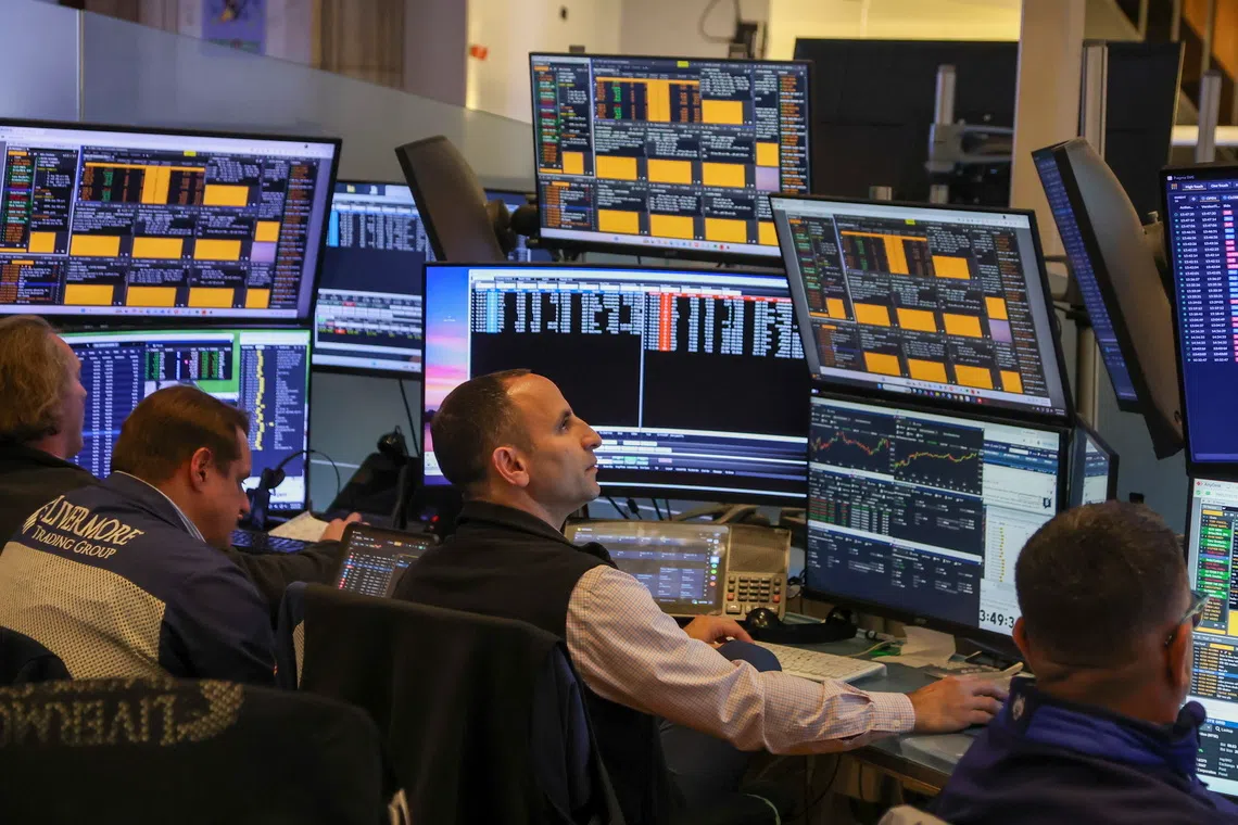 Traders work on the floor of the New York Stock Exchange before the closing bell in New York City, on Oct 6.