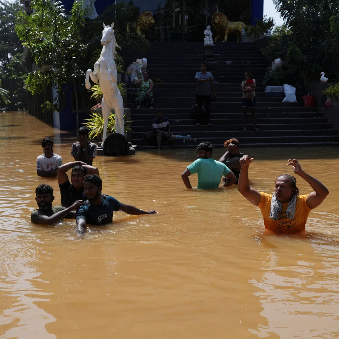 People wading through a flooded street following Cyclone Ditwah's arrival in Kelaniya, Sri Lanka, on Nov 30.