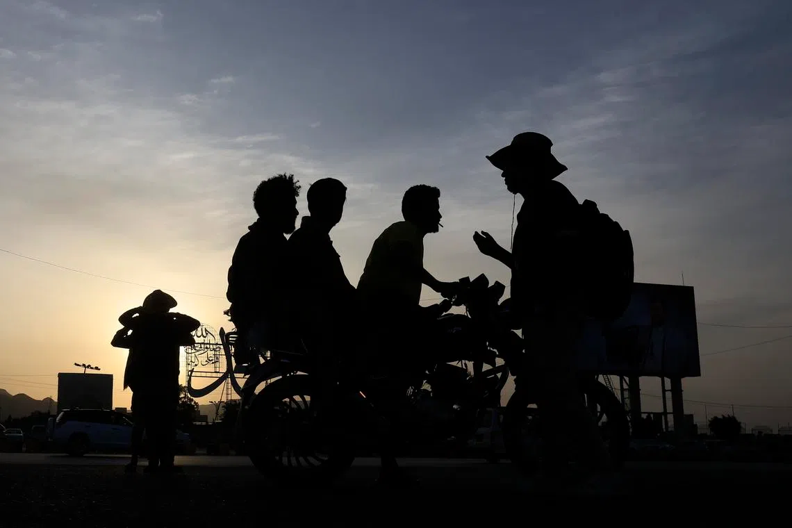 People are silhouetted against the setting sun on a street in Sana'a, Yemen,on June 18, 2026. 