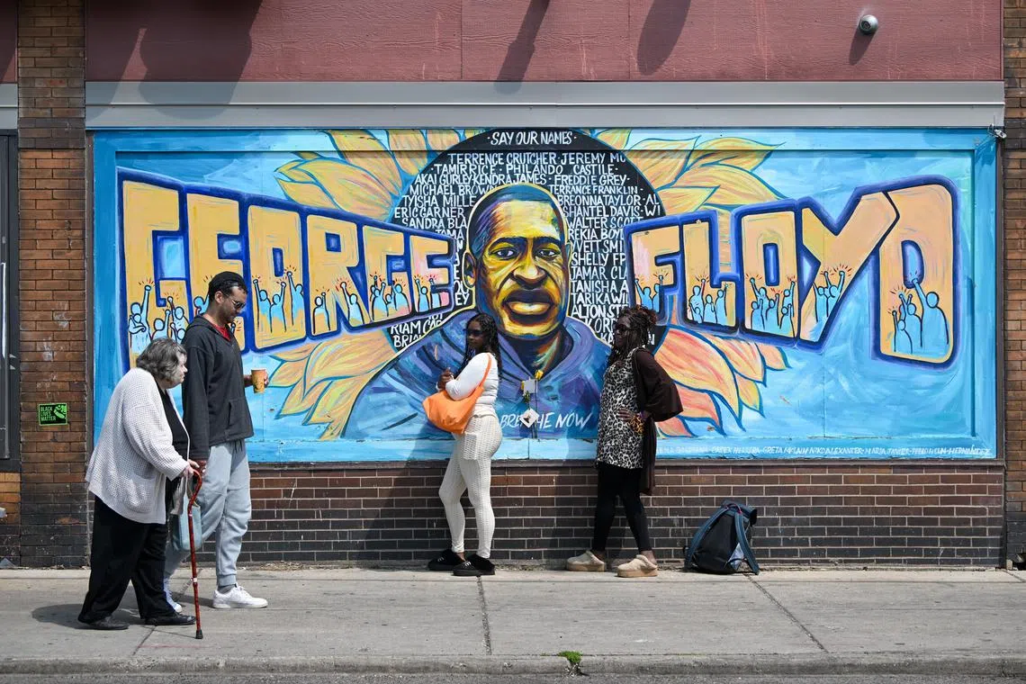 People walk past a mural of George Floyd, created soon after his death, as they gather for a memorial and vigil marking the five-year anniversary of his death in Minneapolis, Minnesota.