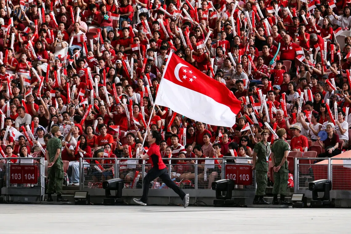 A ceremonial relay of the Singapore state flag during the National Day Parade at the National Stadium on Aug 9.