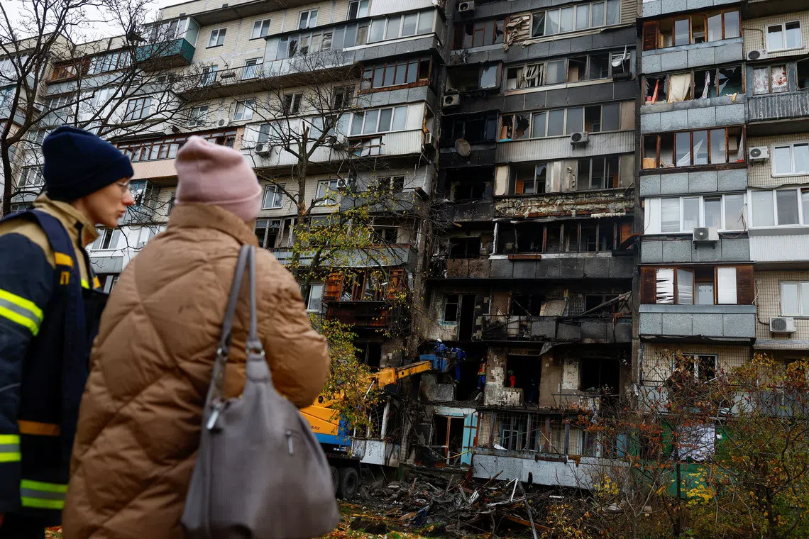 An emergency service psychologist speaks to a resident while she looks at her apartment building which was damaged during an overnight Russian drone strike, amid Russia's attack on Ukraine, in Kyiv, Ukraine October 26, 2025. REUTERS/Valentyn Ogirenko