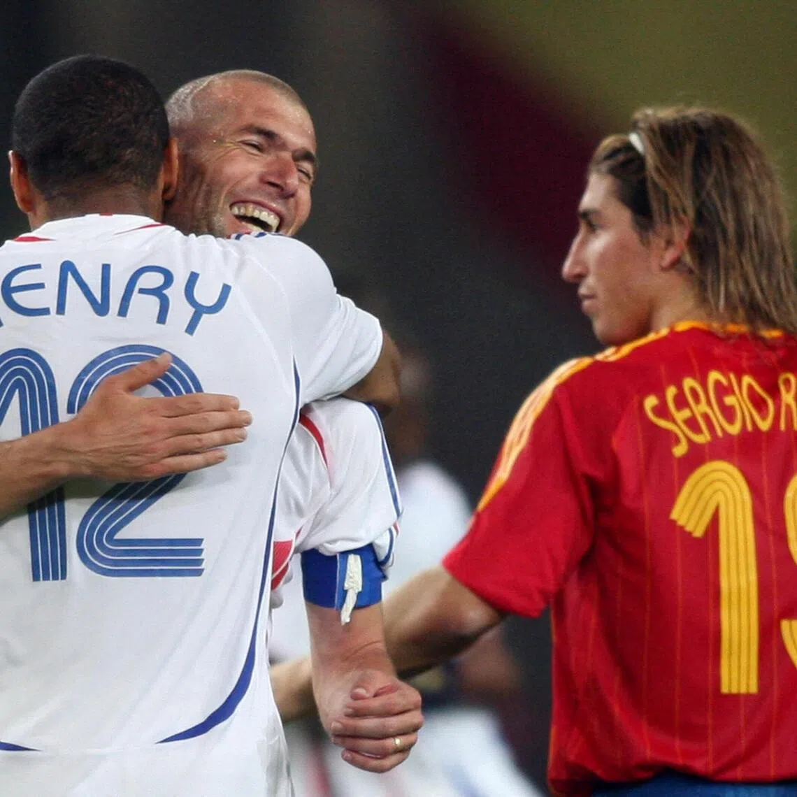 (FILES) French forward Thierry Henry (L) and teammate midfielder Zinedine Zidane (C) celebrate next to Spanish defender Sergio Ramos (R) at the end of the World Cup 2006 round of 16 football game Spain vs. France, on June 27, 2006 at Hanover stadium. (Photo by Patrik STOLLARZ / AFP)