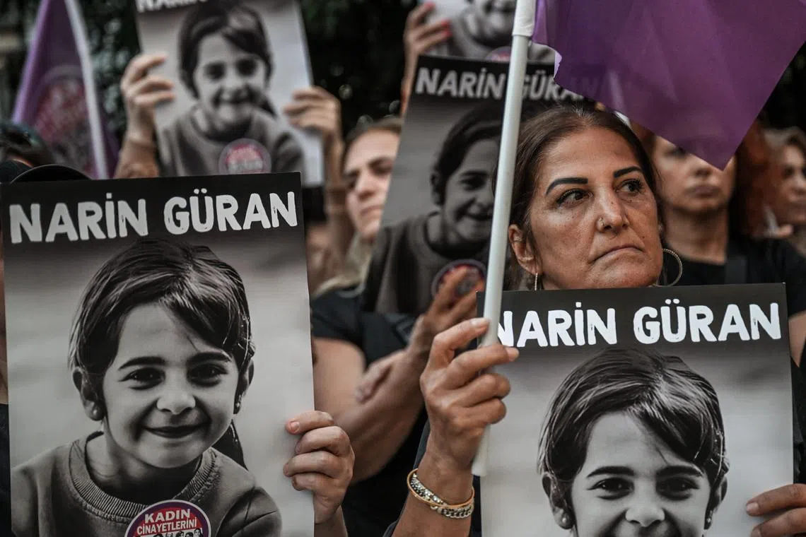 Protesters hold portraits of eight-year-old Narin Guran, whose body was found after being missing for 19 days.