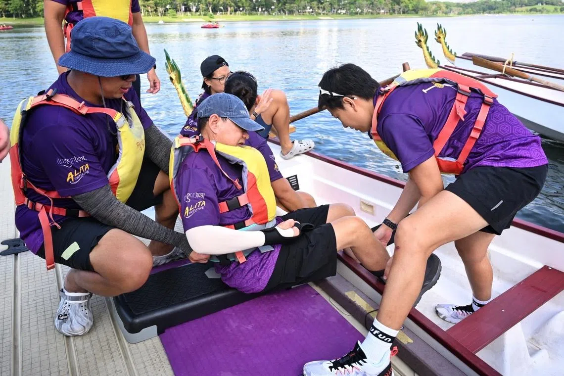 Purple Paddle Fest participant getting helped into the dragon boat for the races at the Purple Paddle Fest on July 5.