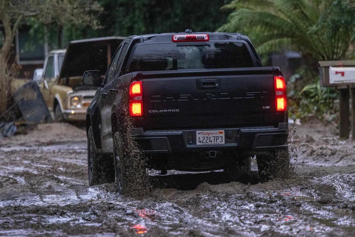 A truck drives along a muddy street in Felton, California, on Jan 14, 2023.