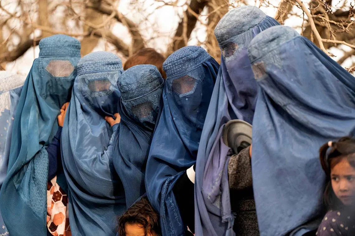 Afghan burqa-clad women wait in a queue to receive free iftar meal during the Islamic holy fasting month of Ramadan, on the outskirts of Kabul on March 12.