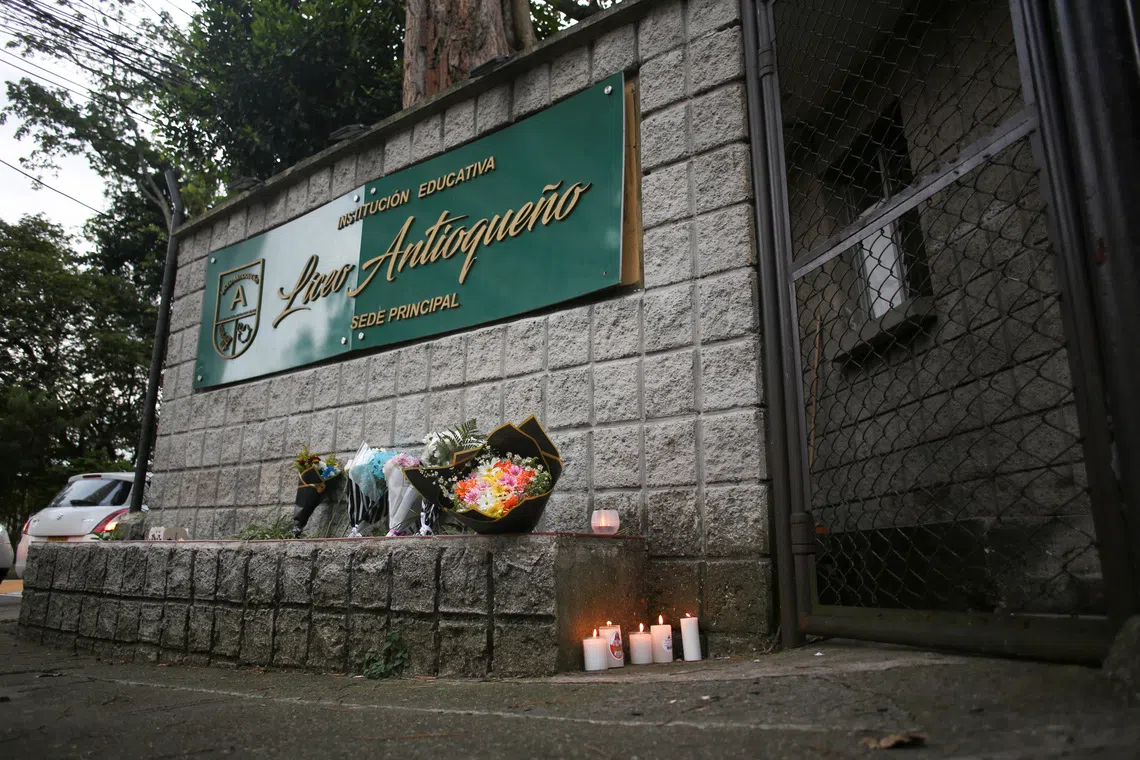 Candles are placed at a makeshift memorial at the Liceo Antioqueno school, where victims of a recent bus accident had studied, in Bello, Colombia, December 14, 2025. REUTERS/Juan David Quintero