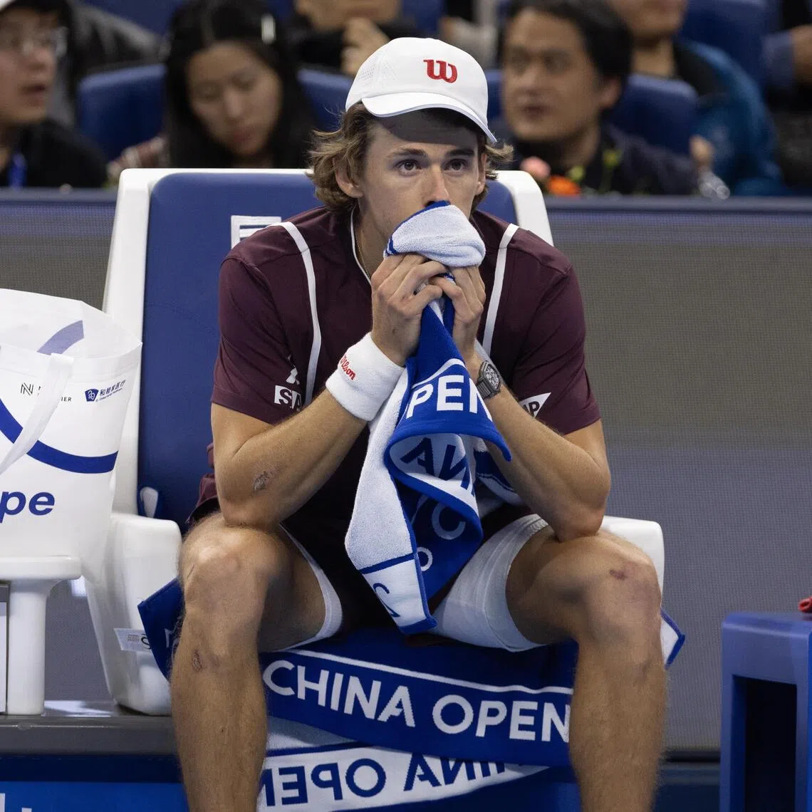 Alex De Minaur reacts after retiring from the men’s final singles match against Novak Djokovic at the China Open in Beijing on Oct 6.