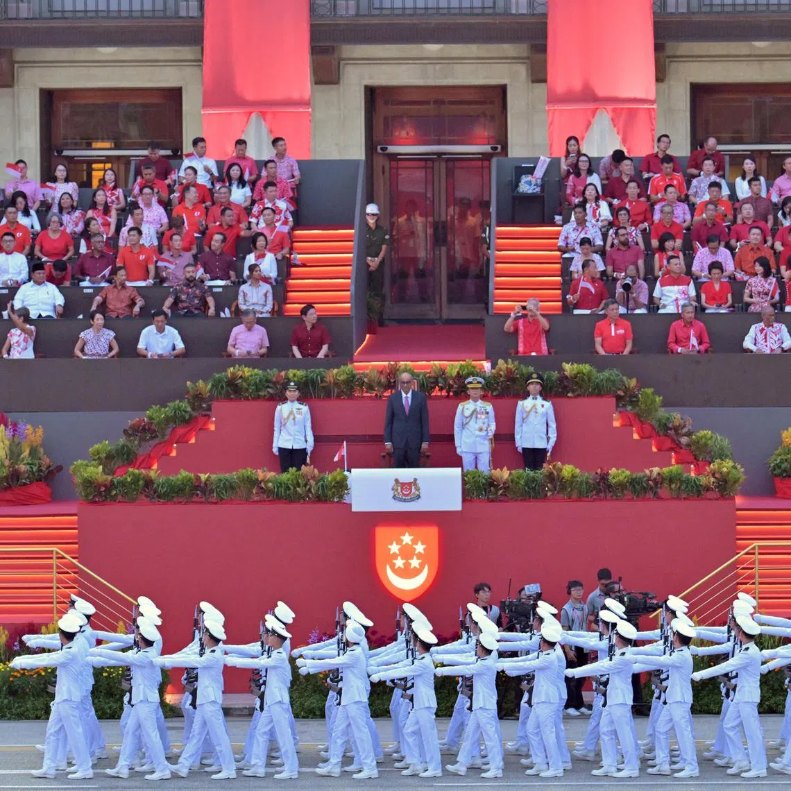 The Republic of Singapore Navy's guard-of-honour contingent marching before President Tharman Shanmugaratnam, as well as ministers and MPs in front of the former City Hall building.
