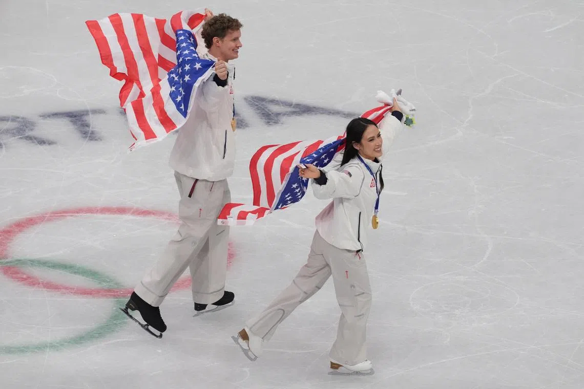 Feb 8, 2026; Milan, Italy; Madison Chock and Evan Bates of the United States of America celebrate after winning gold in the figure skating team event during the Milano Cortina 2026 Olympic Winter Games at Milano Ice Skating Arena. Mandatory Credit: Amber Searls-Imagn Images
