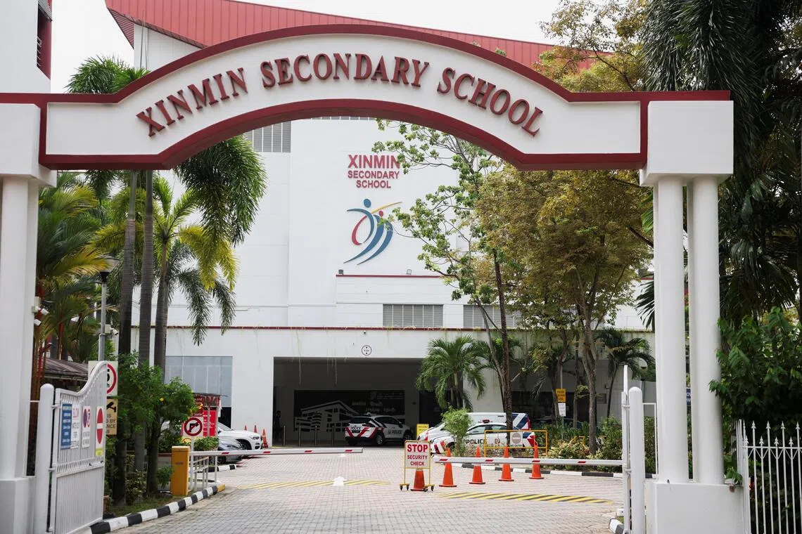 Police vehicles parked at Xinmin Secondary School following a bomb threat on Aug 13.