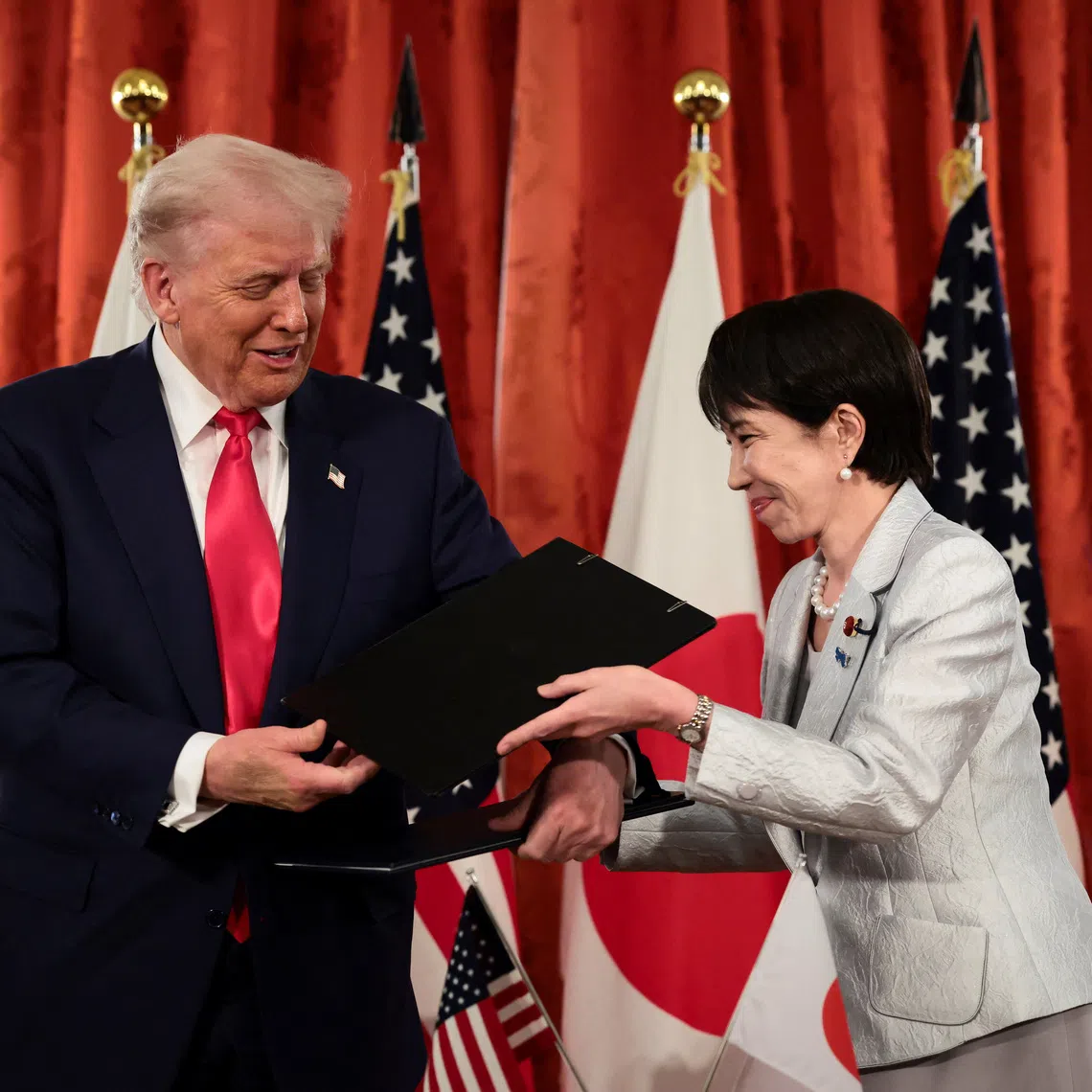 U.S. President Donald Trump and Japanese Prime Minister Sanae Takaichi hold signed documents regarding securing the supply of critical minerals and rare earths, at a bilateral meeting at Akasaka Palace in Tokyo, Japan, October 28, 2025. REUTERS/Evelyn Hockstein