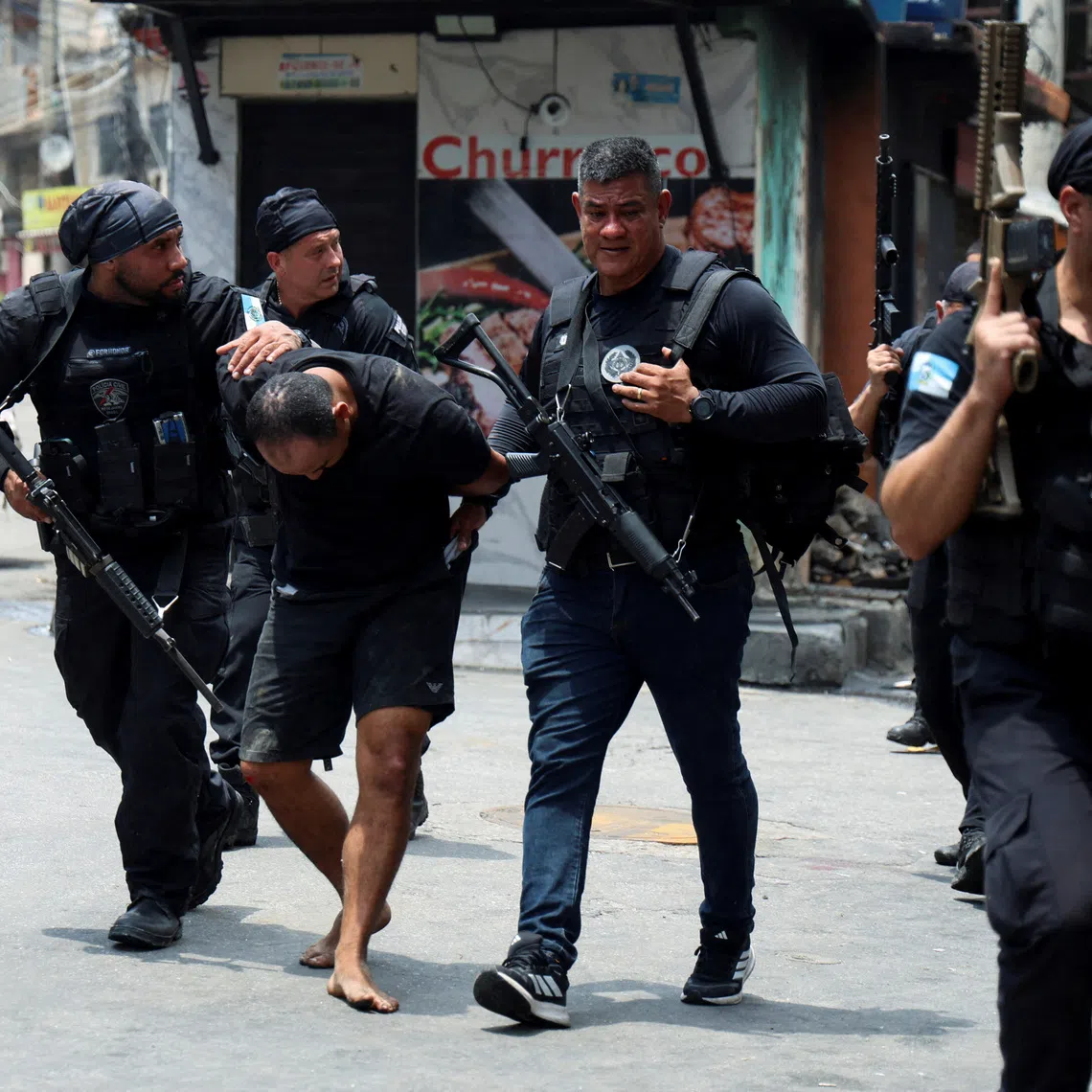 FILE PHOTO: A man is detained by police officers during a police operation against drug trafficking at the favela do Penha, in Rio de Janeiro, Brazil October 28, 2025. REUTERS/Aline Massuca/File Photo