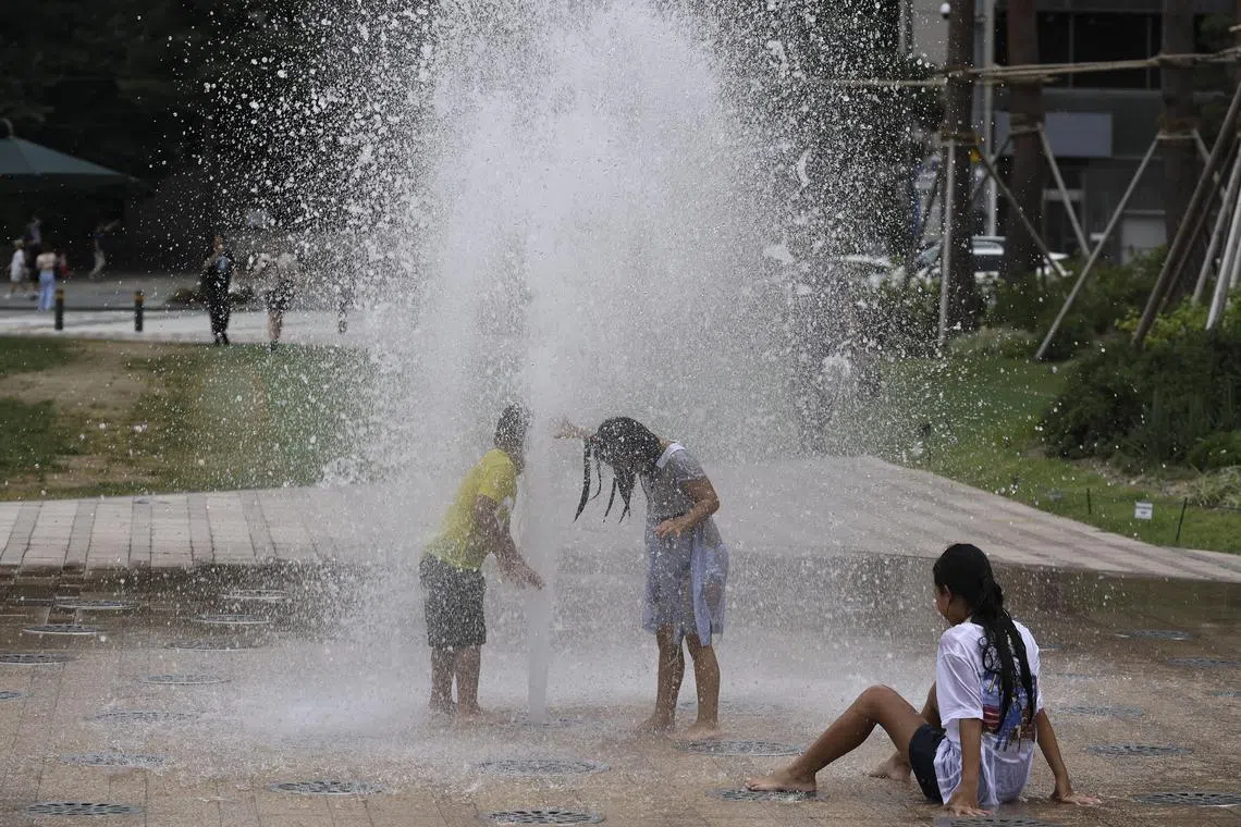 epa11549497 Children cool off in a fountain in Gwanghwamun square in Seoul, South Korea, 15 August 2024. A heat wave continues to affect all areas of South Korea, with temperatures rising to an intra-day high of 36 degrees Celsius in the South Korean capital.  EPA-EFE/JEON HEON-KYUN
