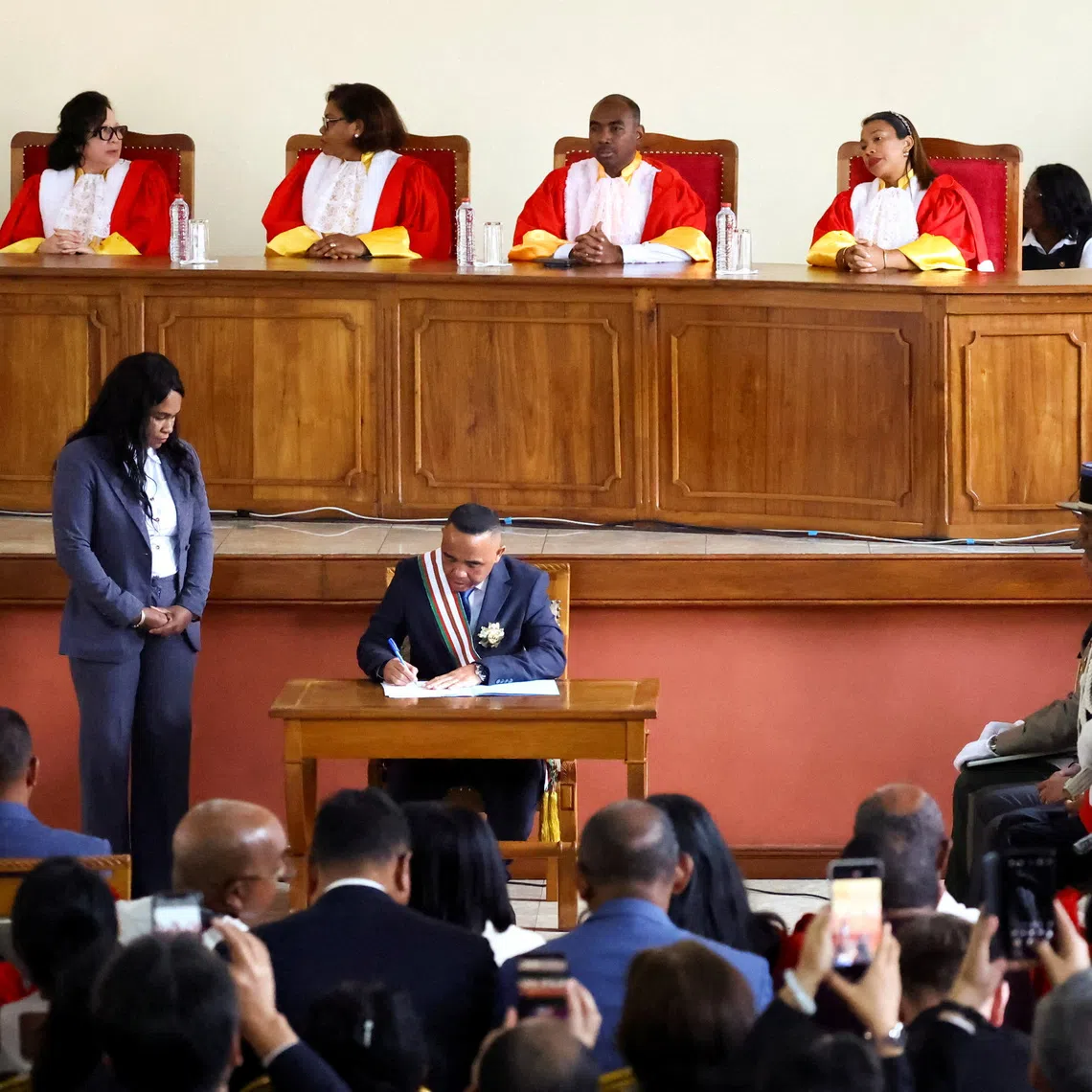 Madagascar's new military ruler, Colonel Michael Randrianirina, signs documents after being sworn in as president on Friday, taking over from Andry Rajoelina following a coup that ousted him, at the constitutional court in Antananarivo, Madagascar, October 17, 2025. REUTERS/Siphiwe Sibeko