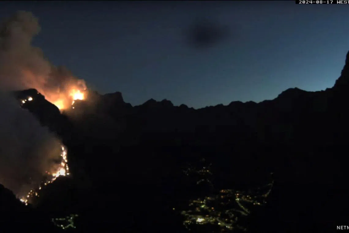 Smoke rises as a wildfire burns at Curral das Freiras, Madeira, Portugal August 17, 2024, in this screen grab obtained from a social media video. netmadeira.com/via REUTERS/File Photo