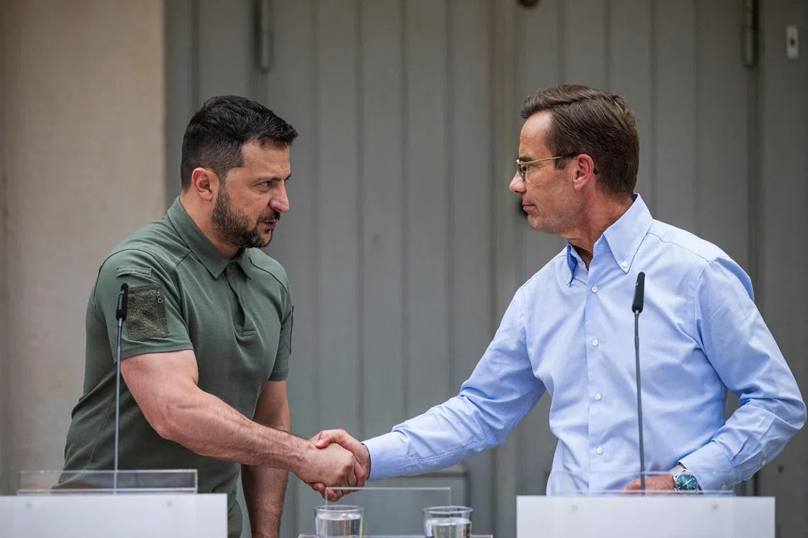 Ukrainian President Volodymyr Zelensky (L) and Swedish Prime Minister Ulf Kristersson shake hands at a joint press conference after talks at the minister's countryside retreat in Harpsund, south-west of Stockholm, Sweden on August 19, 2023. (Photo by Jonathan NACKSTRAND / AFP)