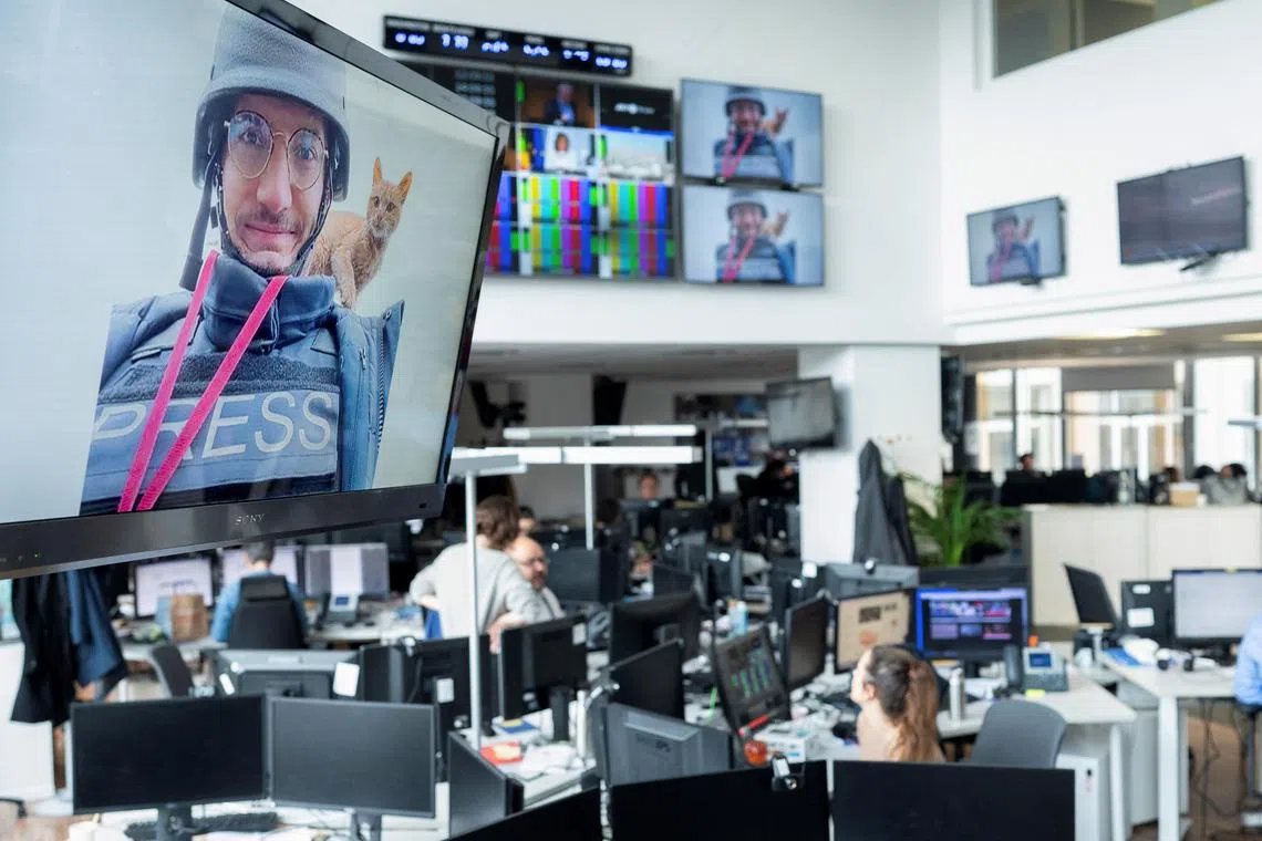 A tribute for journalist Arman Soldin is displayed on screens during a minute's silence held for him at AFP's headquarters in Paris.