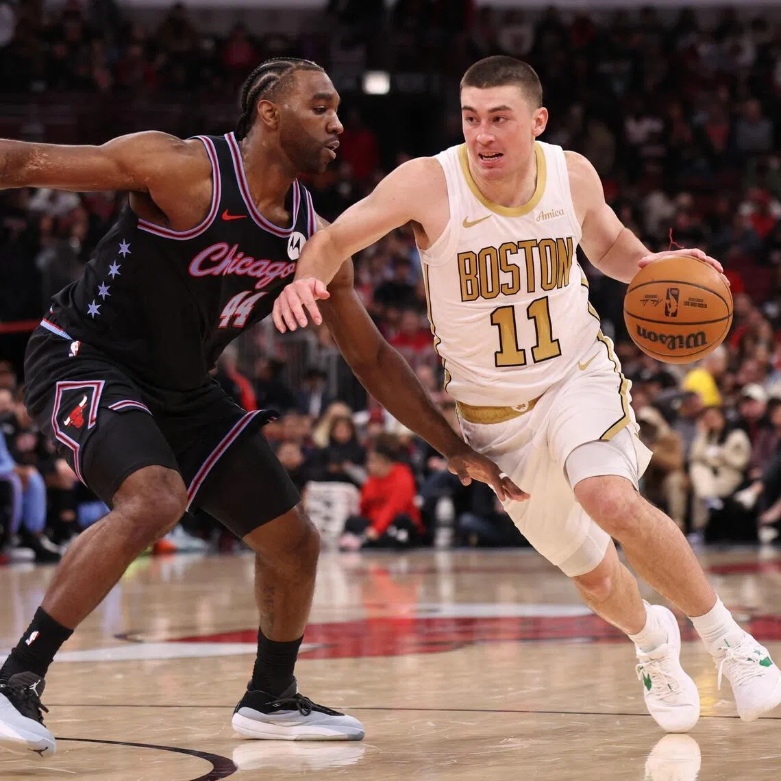 Payton Pritchard of the Boston Celtics dribbles past Patrick Williams of the Chicago Bulls during the first half at the United Center on Jan 24.