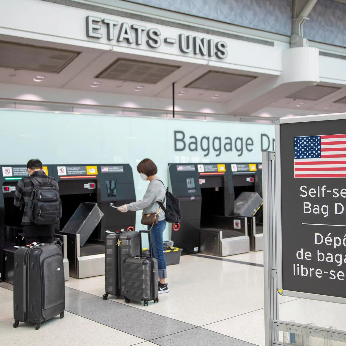 FILE PHOTO: Passengers drop their bags off before walking towards the gates for U.S. travel at Toronto Pearson International Airport in Toronto, Ontario, Canada June 23, 2020.  REUTERS/Carlos Osorio/File Photo