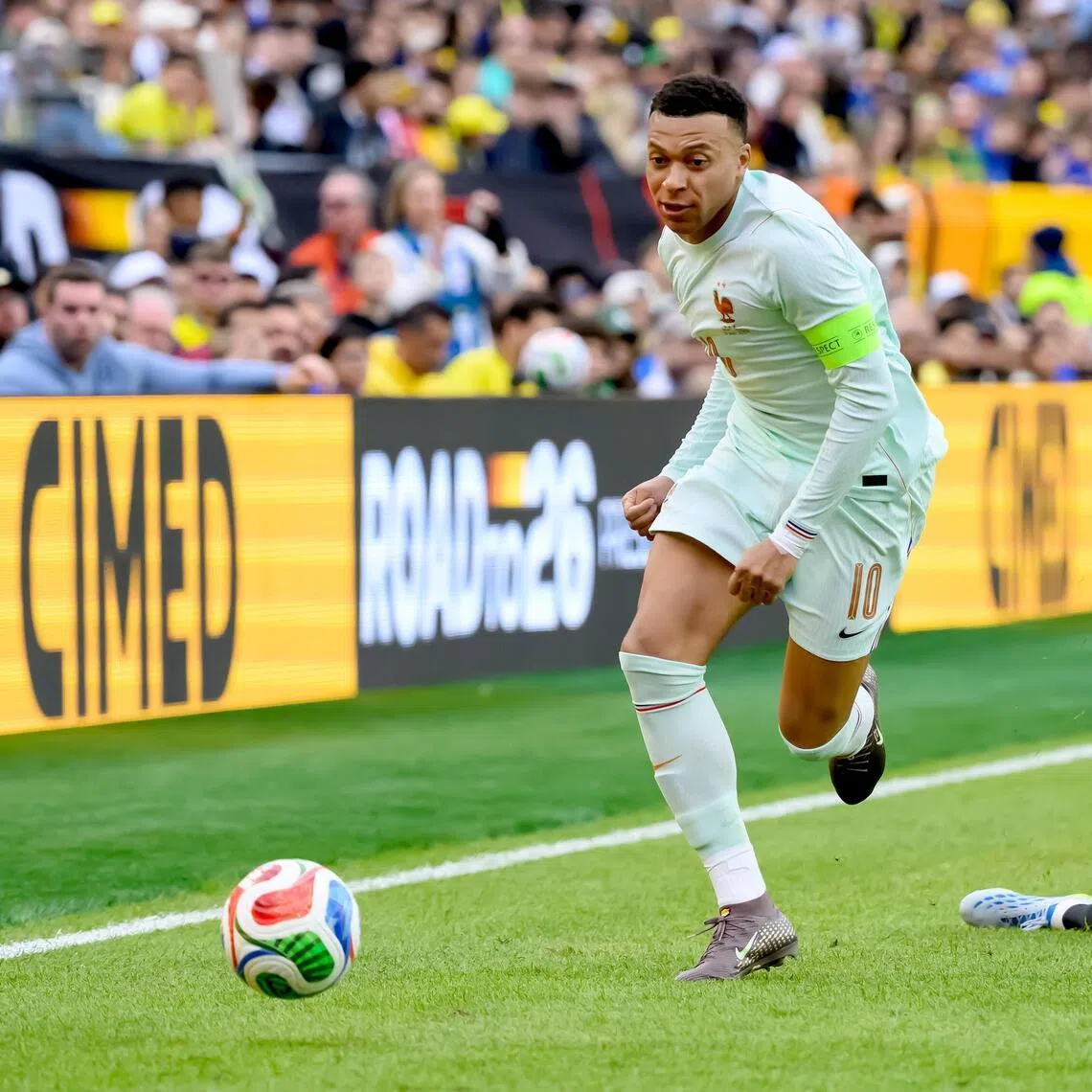 France's Kylian Mbappe surging clear of Brazil's Raphinha during their friendly on March 26.