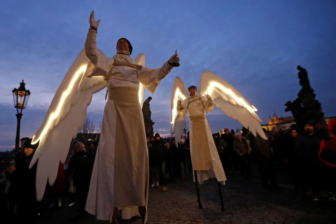 Men dressed as angels walk across the medieval Charles Bridge as a part of Christmas celebrations in Prague, Czech Republic, Dec 11, 2022. 